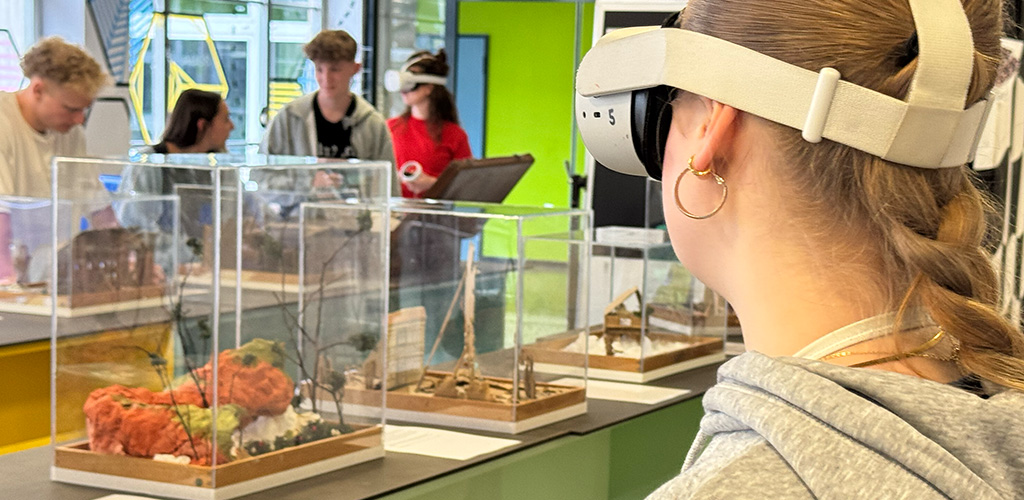 VR Austellung Schülerin mit 3-D-Brille steht vor den Modellen der ausstellung